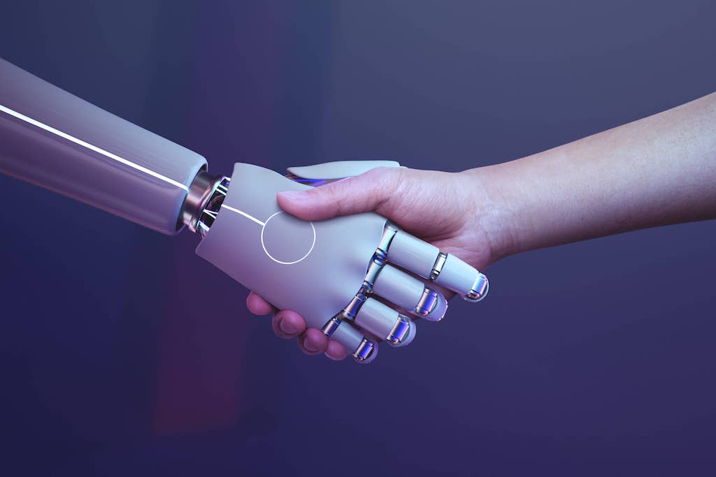 Image of a human shakes hand with a robot