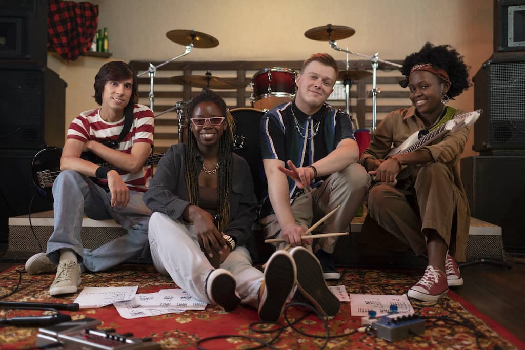 Diverse musicians sitting together in a rehearsal studio, representing a variety of cultural backgrounds and musical styles