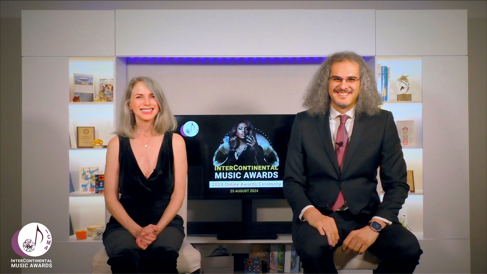 Shahed Mohseni and Karen Lorre presenting the 2024 InterContinental Music Awards online ceremony. Both are dressed in formal attire, in ICMAs office.